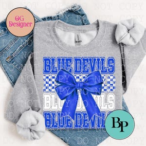May include: A gray sweatshirt with the text "BLUE DEVILS" in blue and white block letters, with a blue bow. The sweatshirt is displayed on a pair of blue jeans.