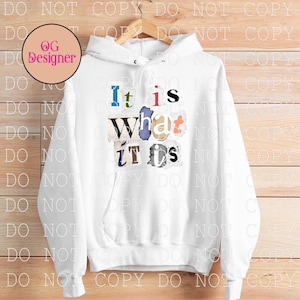 May include: White hoodie with the phrase "It is What it is" in colorful, cut-out style letters. The hoodie has a drawstring hood and a front pocket. The design is centered on the front of the sweatshirt.