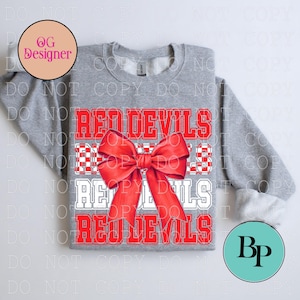 May include: A gray sweatshirt with the text "RED DEVILS" in red and white block letters. A large red bow is centered on the front. The sweatshirt is a casual style.