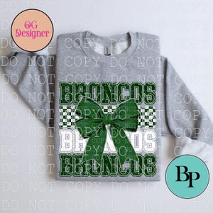 May include: A heather grey crewneck sweatshirt featuring a large green hair bow graphic centred over the repeated text BRONCOS in a collegiate font. The design includes a checkered pattern background behind the text and bow elements.