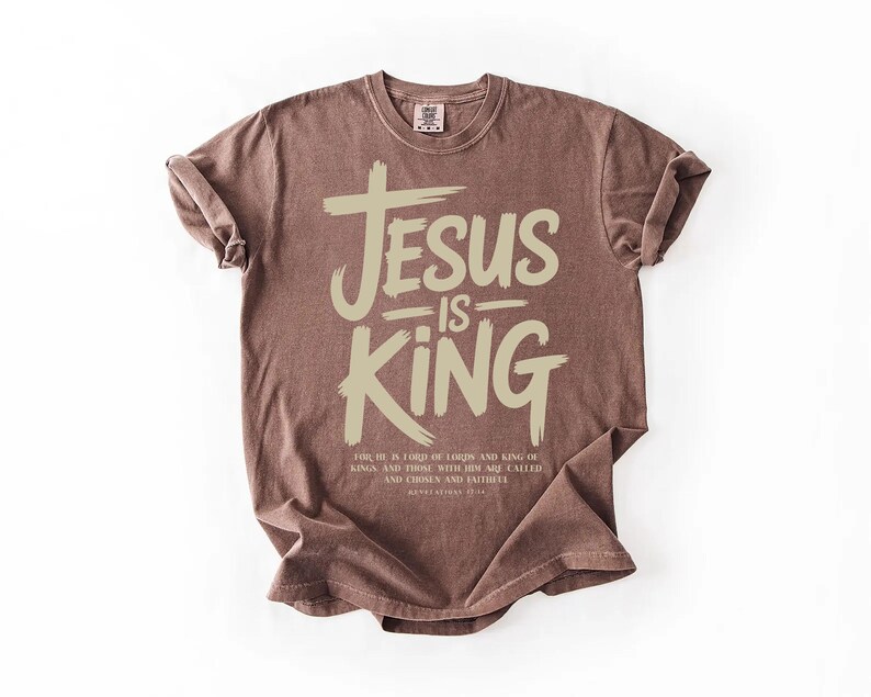 A brown t-shirt with the text "JESUS IS KING" printed on it.