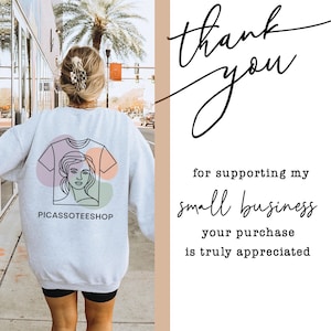 a person walking down a street, wearing a white sweatshirt with a graphic design on the back. The person is also carrying a handbag. The image includes text that reads "Thank you for supporting my small business your purchase is truly appreciated".