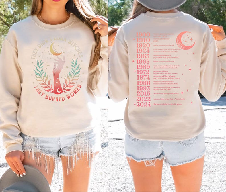 a woman wearing a white sweatshirt with a graphic design on the front and a list of years on the back.