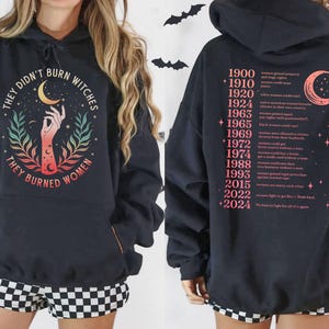 a black hoodie with a graphic design and text on the back.
