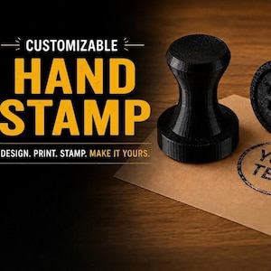 Op de afbeelding: Twee zwarte, cilindrische handstempels met een uitlopend handvat. Eén stempel staat rechtop, terwijl de andere op zijn kant ligt en de ronde basis met de in reliëf gedrukte tekst 'YOUR TEXT' toont. Een bijpassende ronde afdruk is zichtbaar.
