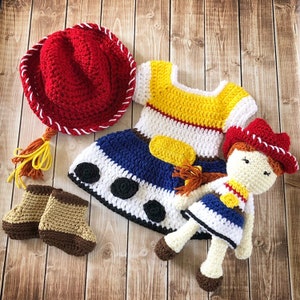 以下が含まれることがあります： トイストーリーのキャラクター、ウッディをモチーフにした、かぎ針編みベビー服。赤いカウボーイハット、黄色、青、白のドレス、茶色のブーティが含まれています。同じような衣装を着た、かぎ針編みのドールも含まれています。