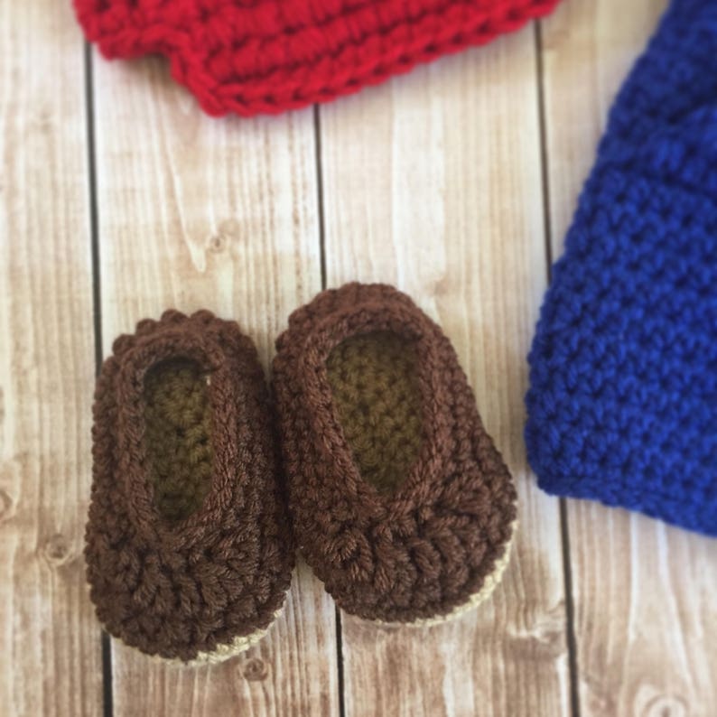 Pu&ograve; includere: Un paio di scarpine per neonati in crochet marroni con suola beige.