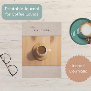 Op de afbeelding: Een tijdschrift getiteld "Mr. Java Journal" met een kopje koffie op een houten oppervlak. Een turquoise kopje koffie met latte art staat op een turquoise schotel. De woorden "Printable Journal for Coffee Lovers" en "Instant Download!" zijn ook zichtbaar.