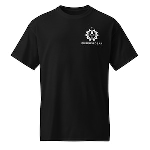Puede incluir: Una camiseta negra de manga corta con un gráfico blanco en la parte superior izquierda del pecho. El gráfico consiste en un icono de engranaje que rodea una aguja de brújula con una estrella encima, situado sobre el texto PURPOSEGEAR en mayúsculas.