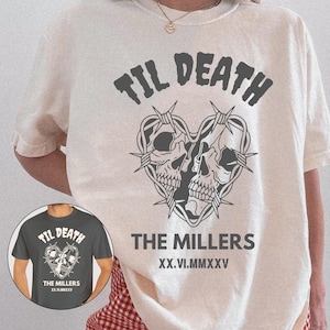 May include: A cream-colored t-shirt with a graphic design featuring two skulls forming a heart shape, intertwined with barbed wire. The text "TIL DEATH" is above the heart, and "THE MILLERS" and Roman numerals are below. The shirt is a pepper print.