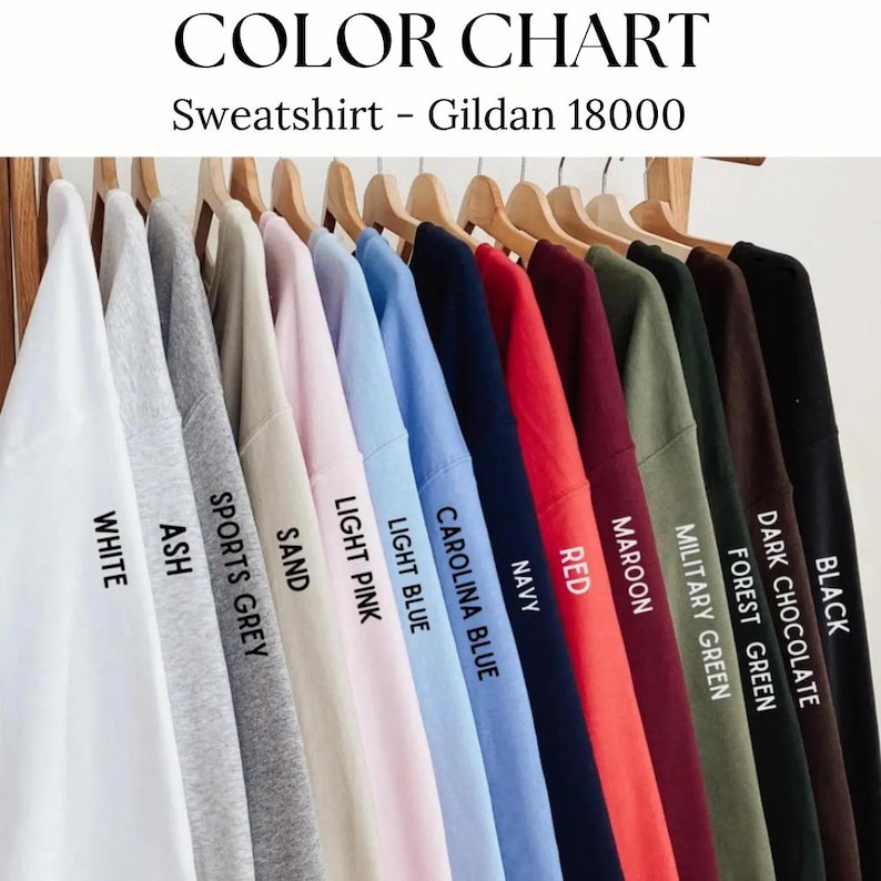 Op de afbeelding: Een kleurenkaart met een verscheidenheid aan sweatshirtkleuren, waaronder wit, as, sportgrijs, zand, lichtroze, lichtblauw, Carolina blauw, marine, rood, bordeaux, legergroen, bosgroen, donkere chocolade en zwart. De tekst luidt "Sweatshirt - Gildan 18000".