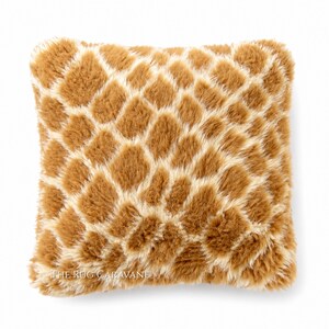 Peut inclure: Coussin carré décoratif avec un motif imprimé girafe. Le coussin présente un motif répétitif de losanges bruns et crème. Le coussin a une texture douce et moelleuse et est probablement en fausse fourrure.