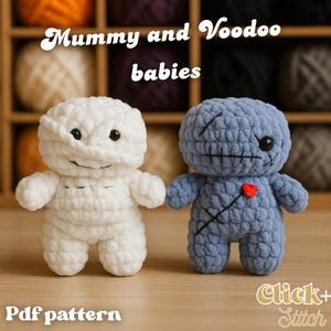May include: Two handmade crochet dolls: a white mummy and a blue voodoo doll. The mummy doll is wrapped in white yarn, with black eyes and a stitched smile. The voodoo doll has stitched features, a red heart, and the text "Mummy and Voodoo babies".