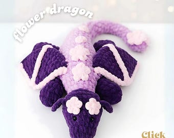Könnte beinhalten: Ein handgehäkelter Drache in Lila- und Rosatönen. Der Drache hat Blumenakzente und Flügel, mit den Worten "flower dragon" und "crochet pattern". Es ist ein weiches, kuscheliges Spielzeug.