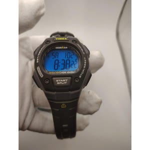 Può includere: Orologio digitale Timex Ironman nero con display blu illuminato. Mostra ora, giorno e data. Funzioni: pulsante start/split e resistenza all'acqua di 100 metri.