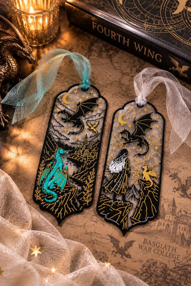 May include: Two rectangular bookmarks with scalloped edges and sheer ribbons. The left bookmark features a turquoise dragon, a black dragon, and a castle. The right bookmark shows a figure with long hair, a black dragon, and a yellow dragon.