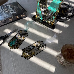 Fourth Wing gift set contents including fantasy dragon book stand two matching bookmarks black base gift box and thank you card.