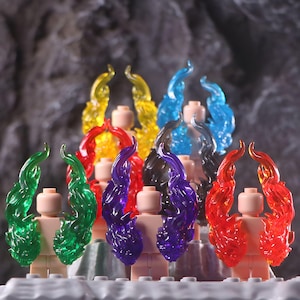 Puede incluir: Colección de accesorios para minifiguras con efectos de llama translúcidos en varios colores. Las llamas son amarillas, azules, rojas, verdes y moradas. Los cuerpos de las minifiguras son de color canela y el fondo es gris oscuro.