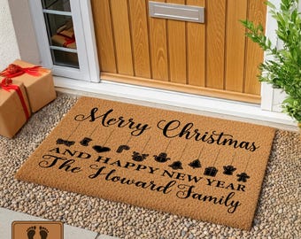 May include: A rectangular doormat with the words "Merry Christmas and Happy New Year" and the family name in black script. The mat is brown with decorative Christmas icons hanging from the text.