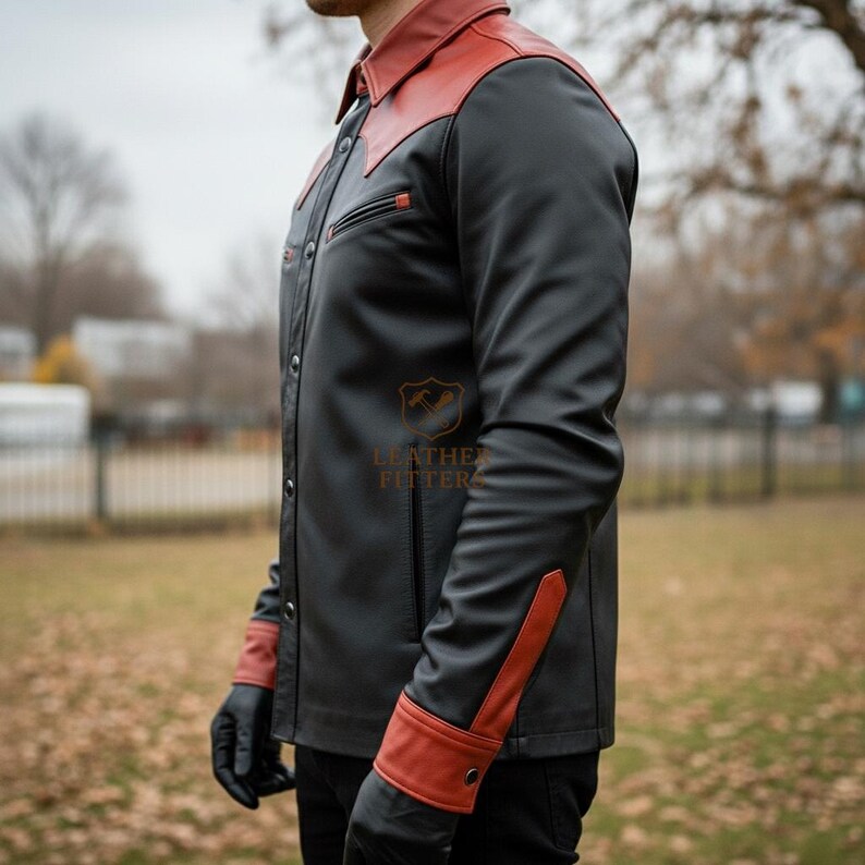 Peut inclure: Veste en cuir noire avec col et poignets rouges. La veste a une fermeture boutonn&eacute;e, une poche poitrine et un logo en bas &agrave; droite. Les poignets ont un accent rouge avec une fermeture boutonn&eacute;e. La veste est port&eacute;e avec des gants noirs.