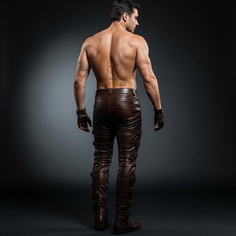 May include: Brown leather pants with multiple straps and buckles. The pants have a fitted design and are worn with fingerless gloves. The image is taken from the back, showcasing the details of the pants.