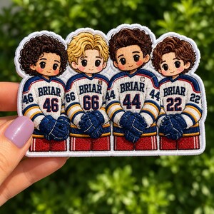 May include: A patch depicting four cartoon hockey players in blue, white, and red jerseys. Each player has a different hair colour and jersey number. The word "BRIAR" is above each number.