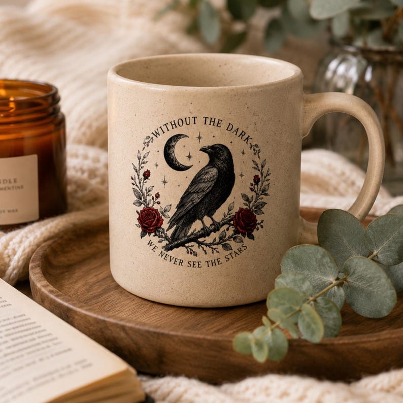 May include: A speckled beige ceramic mug featuring a black raven perched on a branch, surrounded by red roses, a crescent moon, and stars. The text "WITHOUT THE DARK WE NEVER SEE THE STARS" is printed in a circular arc around the central illustration.