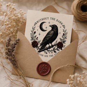 May include: A cream-colored greeting card inside a brown envelope sealed with a red wax stamp. The card features a black ink illustration of a raven perched on a branch, surrounded by a crescent moon, stars, roses, and the text WITHOUT THE DARK WE NEVER SEE THE STARS.