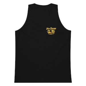 May include: Black tank top with a yellow graphic that reads "Hot Doogy Pickleball Club". The graphic features a pickleball and a hot dog. The tank top is sleeveless and made of a soft material.