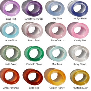 May include: A collection of sixteen colorful, translucent rings in various shades. Colors include lilac, purple, blue, pink, green, orange, and yellow. Each ring has a smooth, polished finish and is labeled with its color name.
