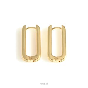 May include: A pair of gold-colored rectangular hoop earrings. The earrings have a hinged closure and a smooth, polished finish. The earrings are shown against a white background.