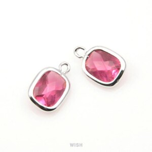 May include: Two rectangular, pink gemstone charms with silver-colored metal frames and small loops at the top. The gems have a faceted appearance, and the charms are set against a white background. The word "WISH" is printed at the bottom.