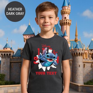 A young boy wearing a black t-shirt with a Disney character printed on it, standing in front of a castle.