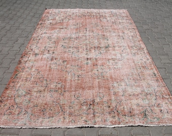 Puede incluir: Una alfombra rectangular de aspecto envejecido, con un diseño floral descolorido en tonos melocotón, crema y negro. La alfombra tiene un aspecto desgastado, con bordes deshilachados, lo que sugiere un estilo antiguo o vintage. Medidas en centímetros.
