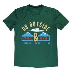 May include: A dark green t-shirt with a graphic that reads "GO OUTSIDE & TRAVEL NOMAD BEFORE YOU RUN OUT OF TIME." The design includes mountains, clouds, and the ampersand symbol.