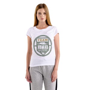 May include: White t-shirt with a crew neck and a circular graphic that reads "TEAM NOMAD ADVENTURE" in green and tan. The shirt is worn by a person wearing gray sweatpants.