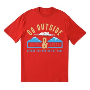 May include: A red t-shirt with the words "GO OUTSIDE" in a gold color, above a graphic of two blue mountains and the words "TRAVEL & NOMAD" in a blue rectangle. The text "BEFORE YOU RUN OUT OF TIME" is below.