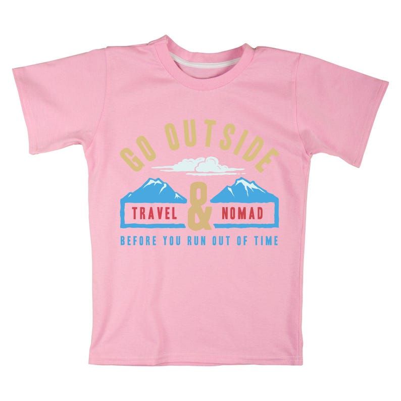 May include: A pink t-shirt with the words "GO OUTSIDE" in a light yellow font. Below the text are two blue mountain illustrations with the words "TRAVEL" and "NOMAD" in blue boxes. The text "BEFORE YOU RUN OUT OF TIME" is below the mountains.