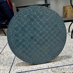 Peut inclure: Un plateau de table rond orné d'un motif en mosaïque bleu sarcelle. La surface se compose de carreaux octogonaux et carrés disposés en grille géométrique, entourés d'une bordure de carreaux rectangulaires, le tout dans un cadre en métal.