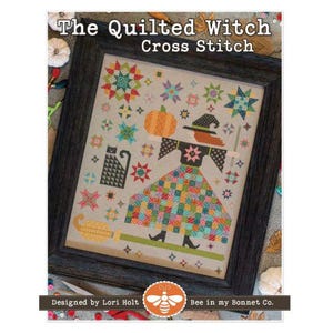 May include: Cross-stitch pattern titled "The Quilted Witch" in a dark wooden frame. The design features a witch with a patchwork dress, a black cat, and a pumpkin. The design is by Lori Holt and Bee in my Bonnet Co.