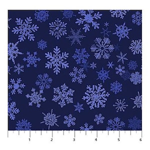 May include: A dark navy blue fabric featuring a repeating pattern of light blue and periwinkle snowflakes in various sizes and intricate geometric designs, positioned above a white ruler showing 6 inches of length for scale.