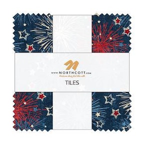 May include: A stack of fabric squares with a patriotic theme. The squares feature a navy blue background with white and red fireworks and star patterns. The center label reads "NORTHCOTT" and "TILES".