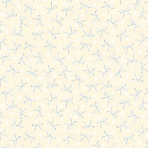 May include: A light yellow fabric featuring a repeating pattern of small, pale blue bows and tiny white polka dots. The textile has a subtle, woven texture visible across the surface, creating a consistent and uniform design throughout the material.