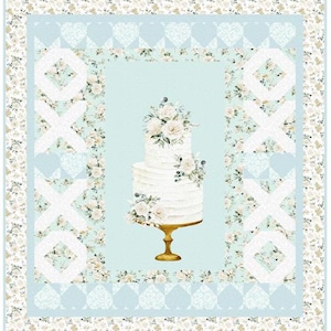 May include: A light blue and white floral quilt with a central image of a two-tiered wedding cake on a gold stand. The quilt features floral and heart patterns, with white "XOXO" designs.