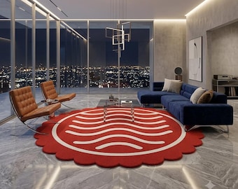 May include: A large, circular, scalloped-edge rug featuring a vibrant red background with a repeating pattern of white, horizontal, wavy lines. The rug is positioned on a polished gray marble floor in a modern living room setting.