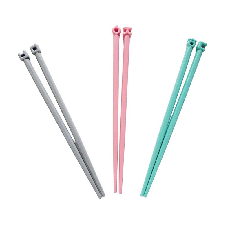 Puede incluir: Tres pares de palillos chinos en diferentes colores: gris, rosa y turquesa. Cada par tiene una parte superior cuadrada con una peque&ntilde;a muesca. Los palillos est&aacute;n hechos de un material liso y s&oacute;lido, sobre fondo blanco.