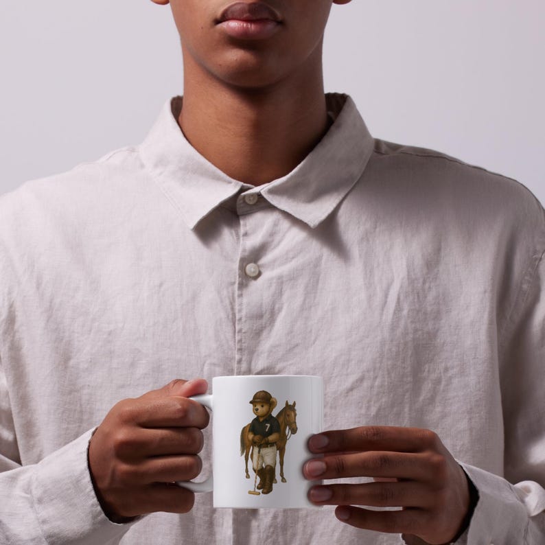 May include: White ceramic mug with a cartoon bear in polo gear, holding a mallet, and standing beside a brown horse. The bear is wearing a cap and a black polo shirt with the number 7. A classic design for a tea or coffee mug.
