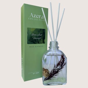 May include: A clear glass reed diffuser bottle with white reeds and a green box. The box reads "Azera Collective" and "Moonlit Forest". The bottle contains dried botanicals and 100ml of liquid.