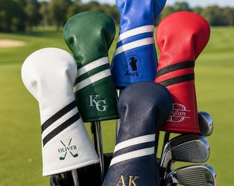Puede incluir: Una colección de cinco fundas de cuero para palos de golf en blanco, verde, azul, azul marino y rojo. Cada funda presenta dos rayas y bordados personalizados, incluyendo los nombres Oliver, Jack y Dylan, o las iniciales KG, AK y D.