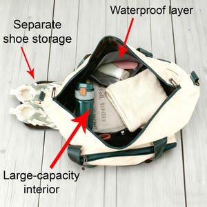 May include: Cream-colored duffel bag with a large-capacity interior, separate shoe storage, and a waterproof layer. The bag has dark green accents and a dark green handle. Inside the bag is a water bottle, towel, and toiletries.